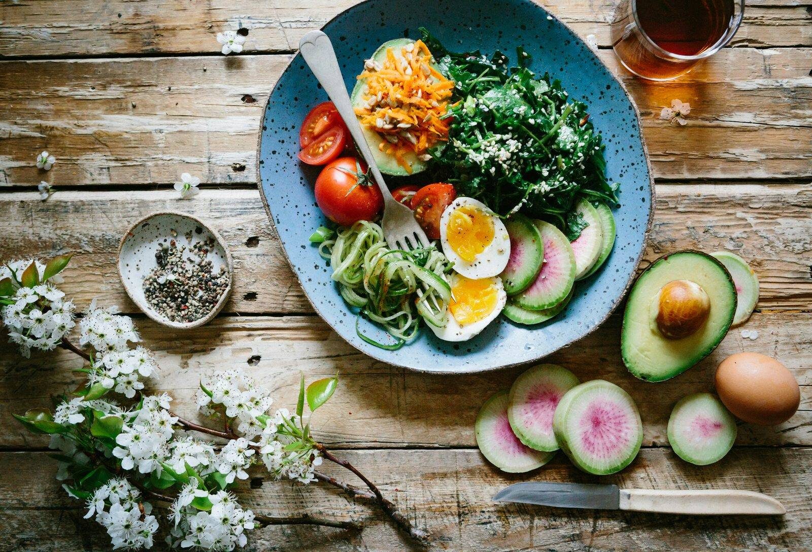 Eiweißreiches Frühstück zur Unterstützung von Blutzucker in der Perimenopause, Eier, Beeren und Nüsse auf hellem Tisch